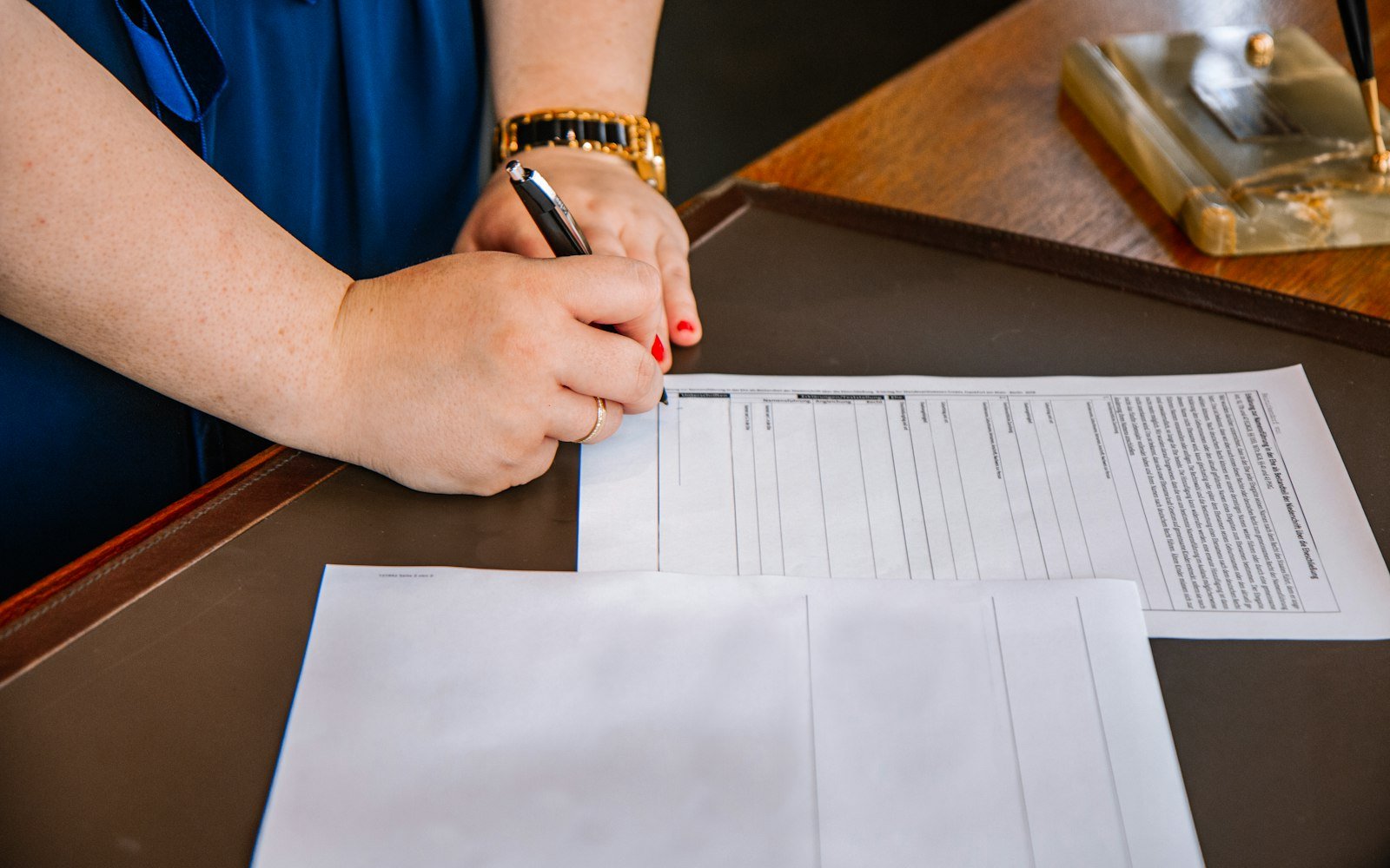 A hand holding a pen over a printed page