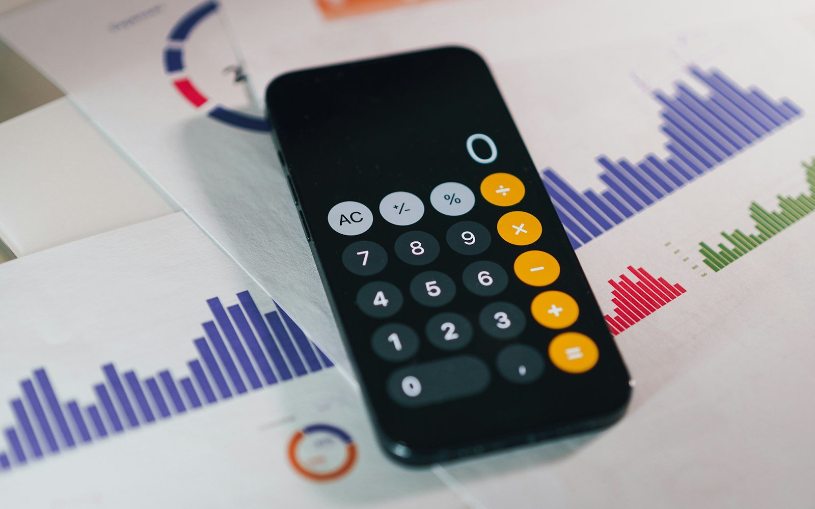 A calculator resting on printed financial reports