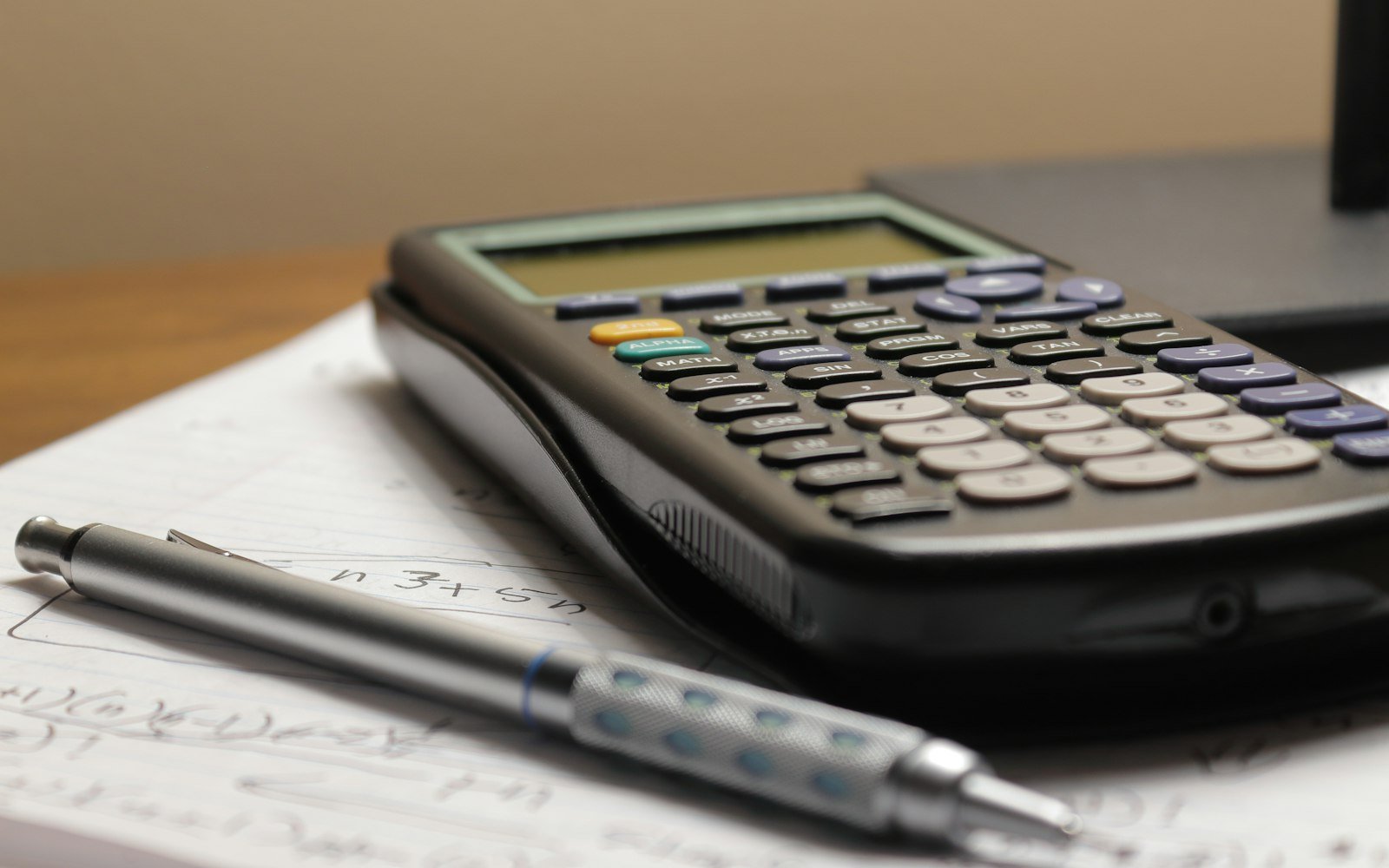 A calculator and a pen on a desk