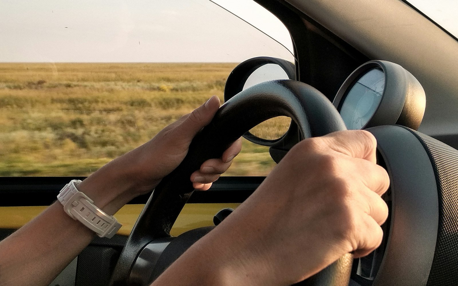 A driver’s hands on a steering wheel