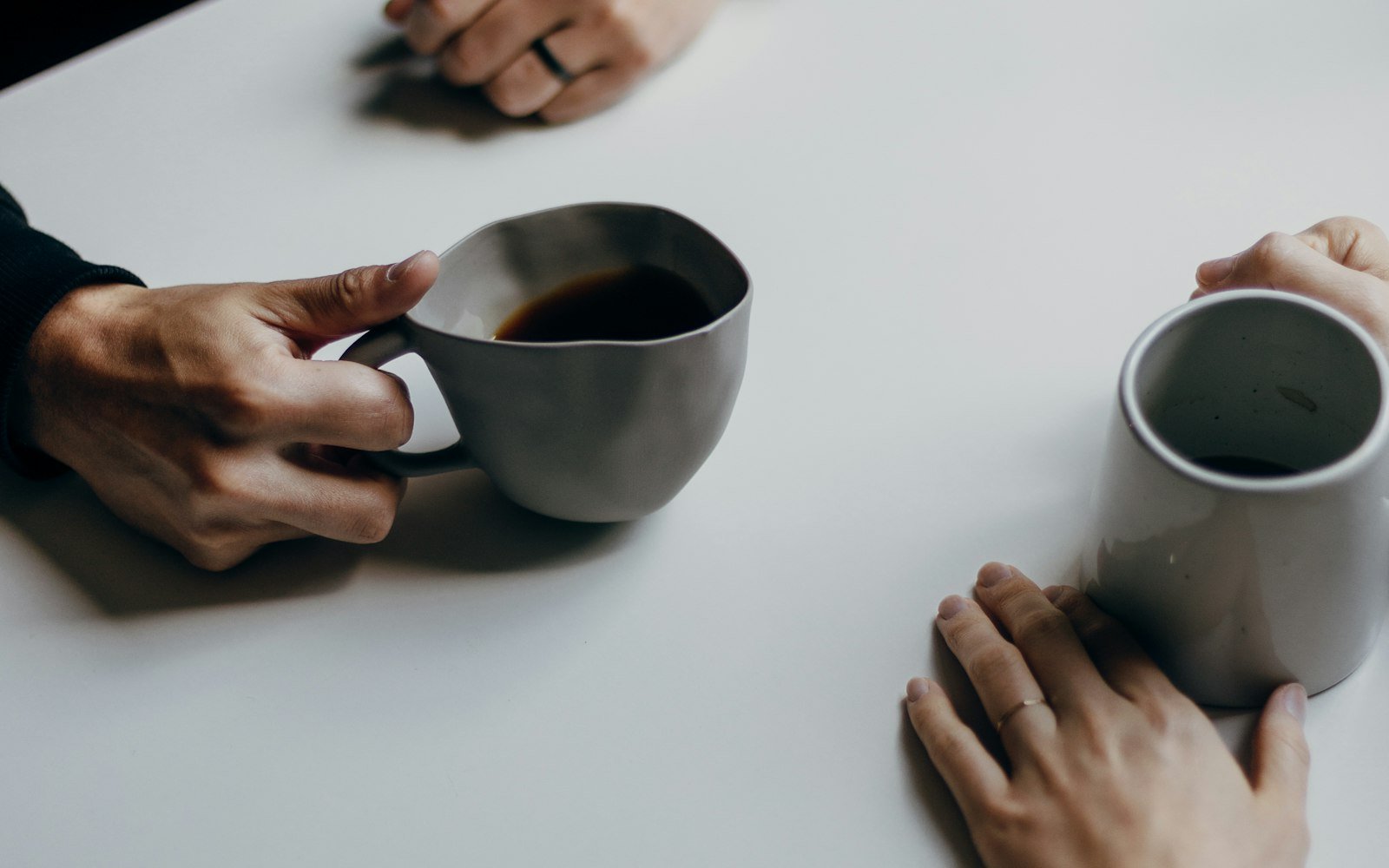 Two people talking over coffee at a table