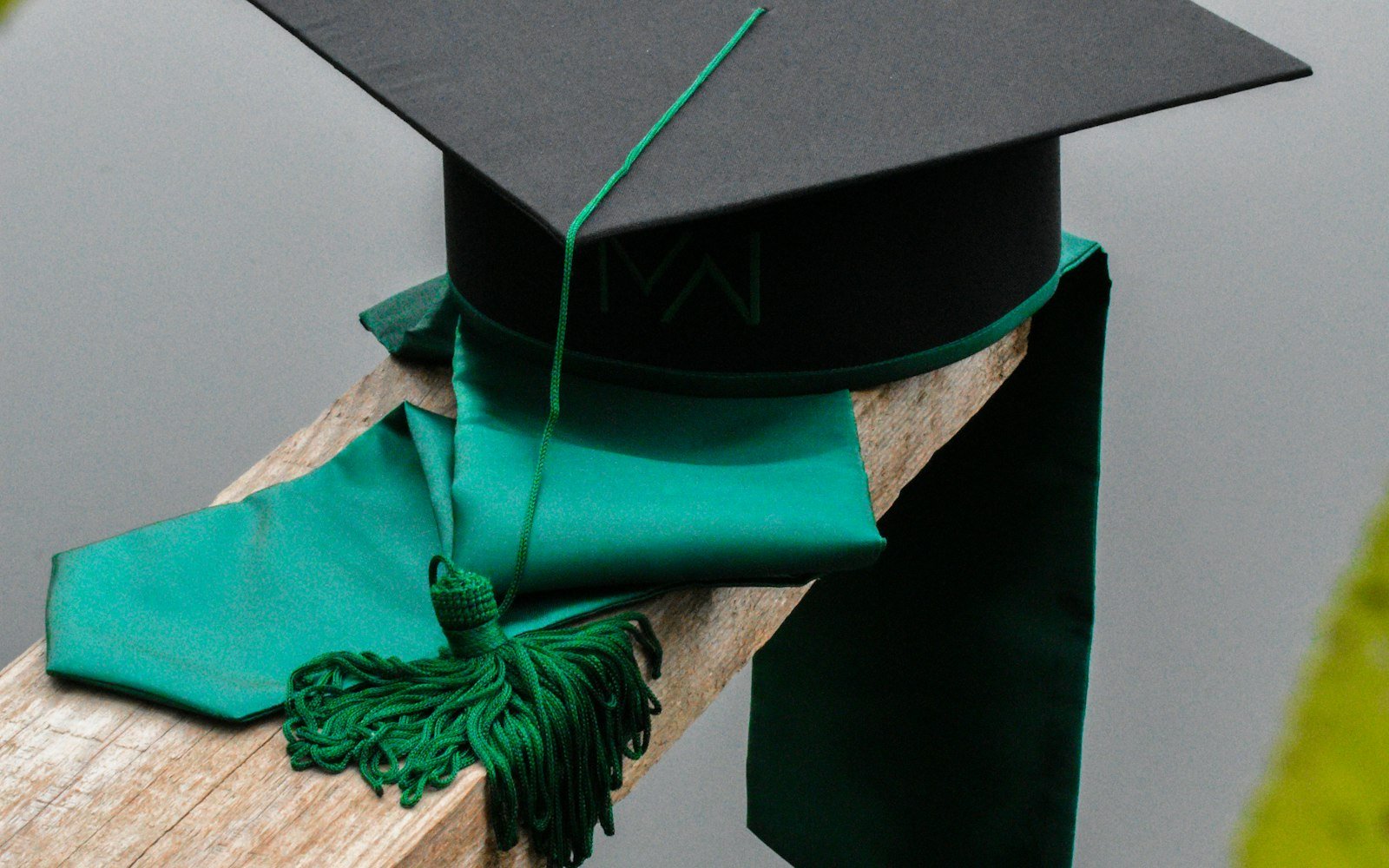 A graduation cap with a green tassel