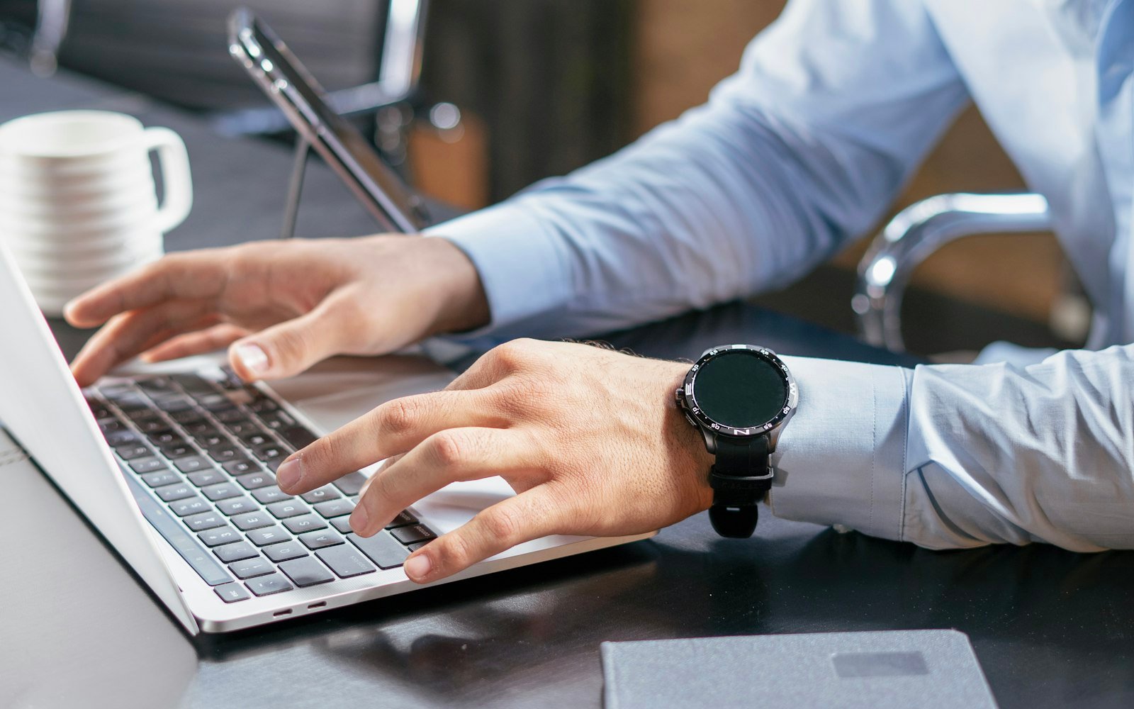 A person typing on a laptop at a desk